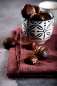 Close-up of chestnuts in bowl with napkin on table