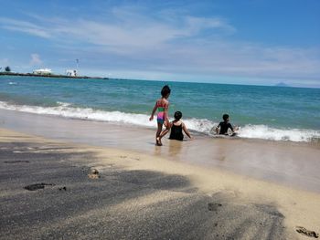 People on beach against sky