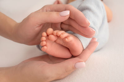 Close-up of woman holding baby hand