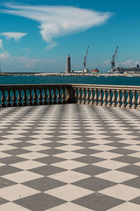 Walkway by sea against sky