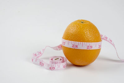 Close-up of orange fruit against white background