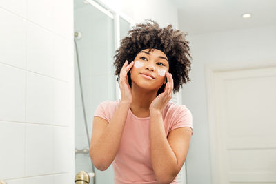 Portrait of beautiful young woman standing in bathroom