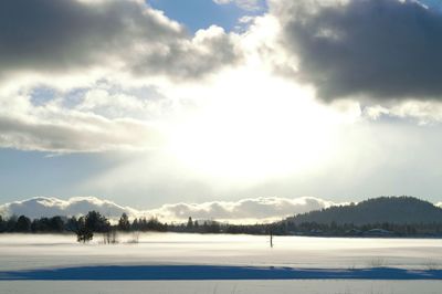 Scenic view of snow covered mountains against cloudy sky