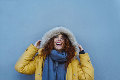 Portrait of smiling young woman standing in snow