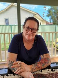 Portrait of smiling young woman sitting on table