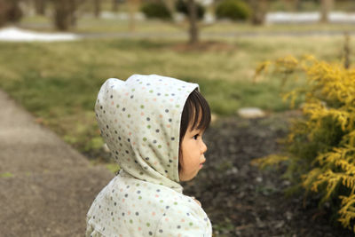 Portrait of a girl looking away against grass