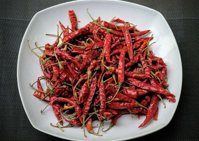 High angle view of red chili peppers in plate on table