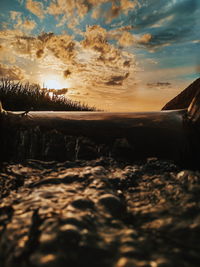 Surface level of land against sky during sunset