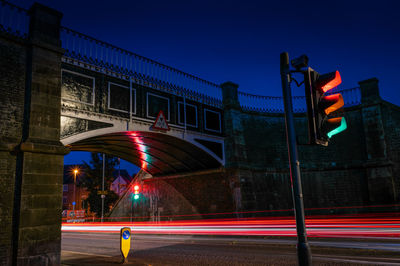 Light trails on road against sky at night