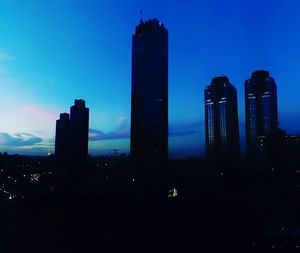 Silhouette buildings against sky at dusk