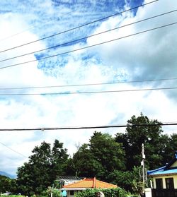 Low angle view of power lines against cloudy sky