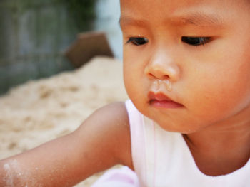 Close-up of cute baby girl looking away 