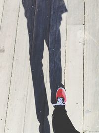 Low section of woman standing on wooden floor