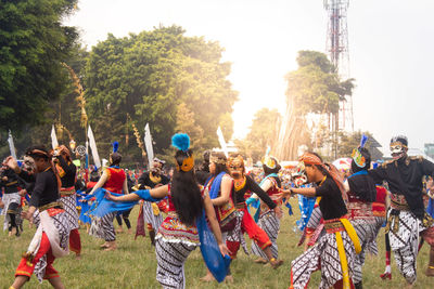 Group of people dancing against sky