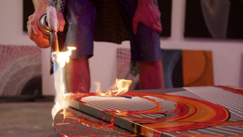 Midsection of man holding candles on table