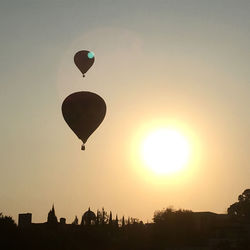 Silhouette hot air balloon flying in sky during sunset