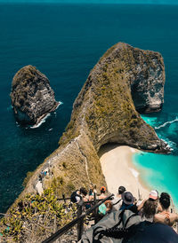 High angle view of people on rock by sea