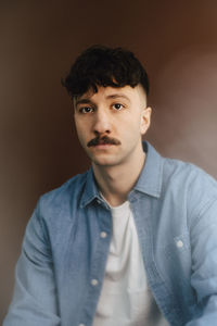 Portrait of confident man against brown background