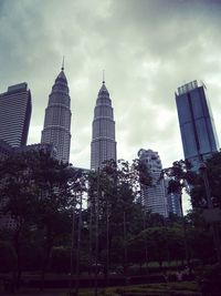 Buildings in city against cloudy sky