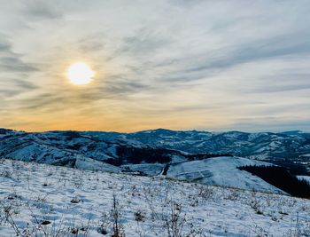 Scenic view of snow covered mountains against sky during sunset