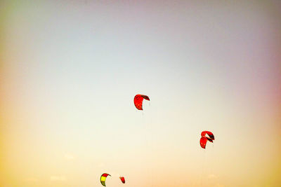 Red paragliding against sky