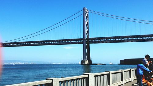 Bridge over sea against clear sky