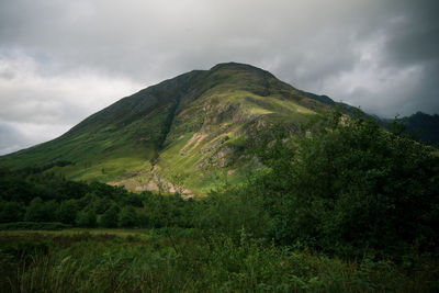 Scenic view of mountains against cloudy sky