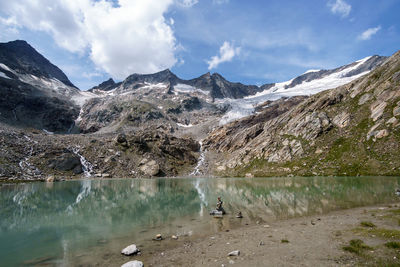 Scenic view of lake by mountains against sky