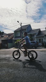 Man riding bicycle on road against sky