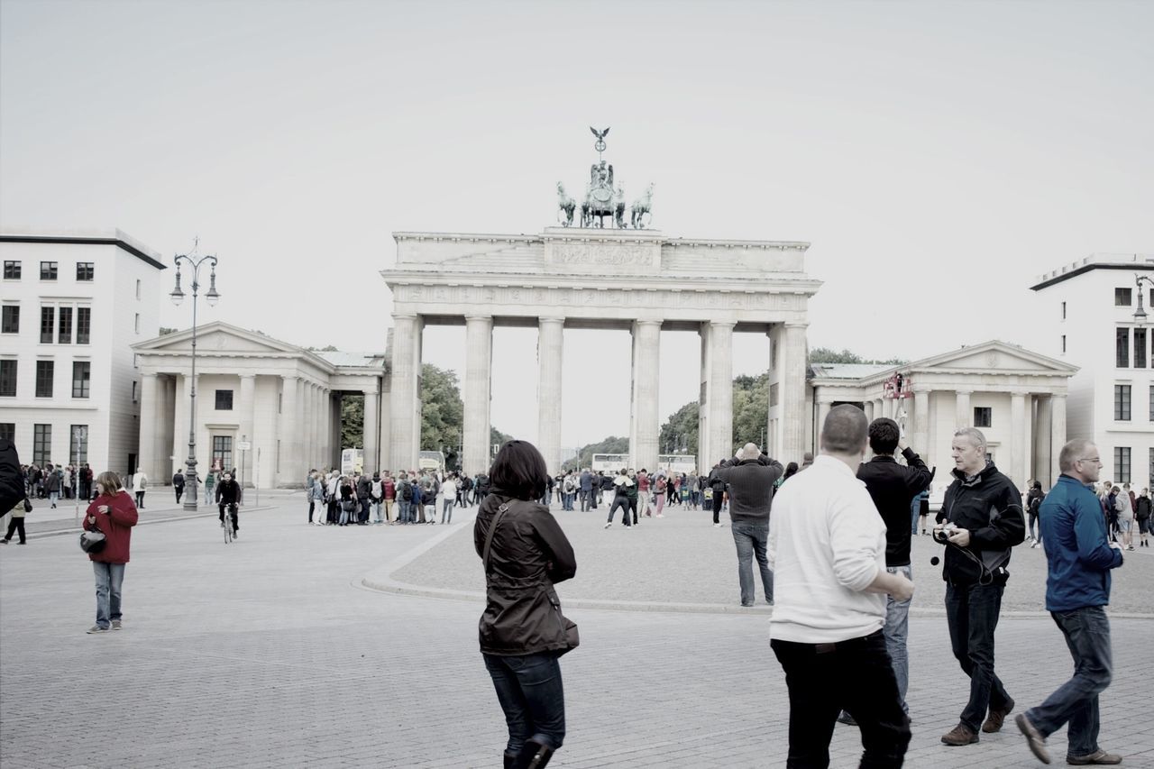 architecture, built structure, building exterior, large group of people, men, walking, person, lifestyles, city, clear sky, city life, street, leisure activity, mixed age range, day, building, tourist, full length, travel