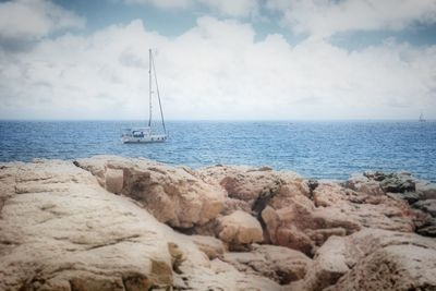 Sailboat sailing on sea against sky