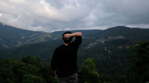 Man looking at mountain range against sky