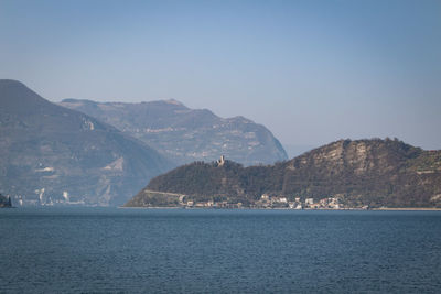 Scenic view of sea and mountains against clear sky