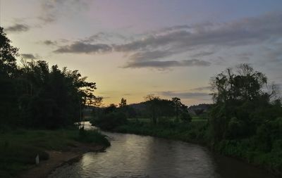 Scenic view of river against sky at sunset