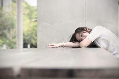 Depressed young woman lying on table
