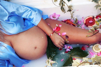 Midsection of pregnant woman lying in bathtub