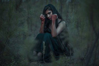 Portrait of beautiful young woman in forest