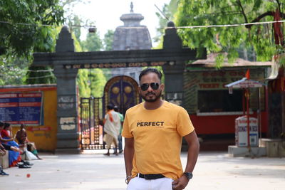 Portrait of young man standing in city