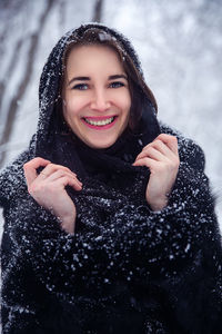 Portrait of a smiling young woman in snow