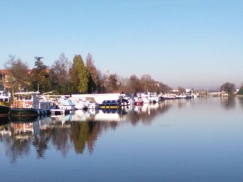 Boats moored in lake against clear sky