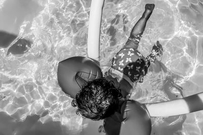 Rear view of girl swimming in pool