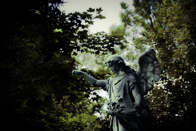 Low angle view of statue against trees