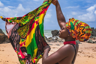 Rear view of women on beach against sky