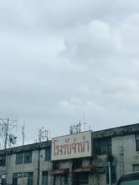 Low angle view of text on building against sky