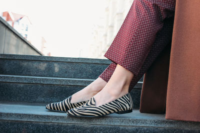 Low section of woman standing on staircase