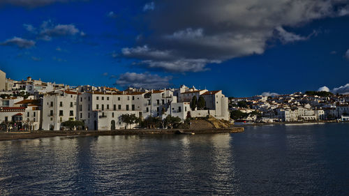 Town by sea against blue sky