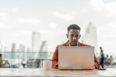 Businessman using laptop in cafe