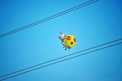 Low angle view of kite flying against clear blue sky