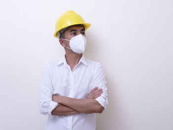 Man wearing hat standing against white background