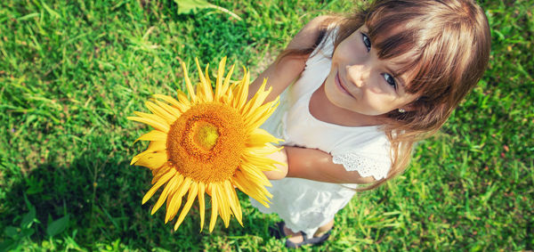Portrait of cute girl holding sunflower